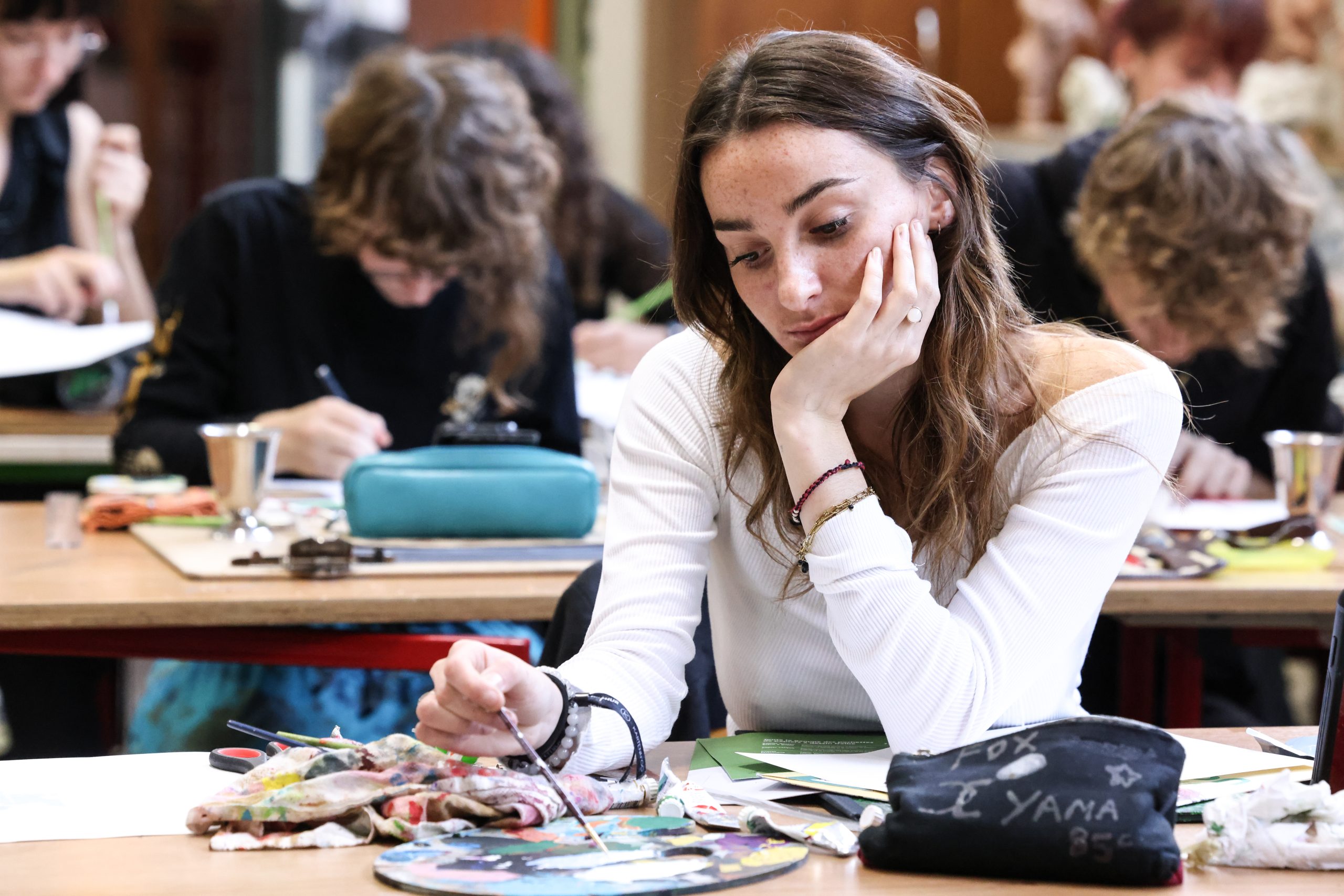 une étudiante pivaut peint à son bureau dans une salle de classe