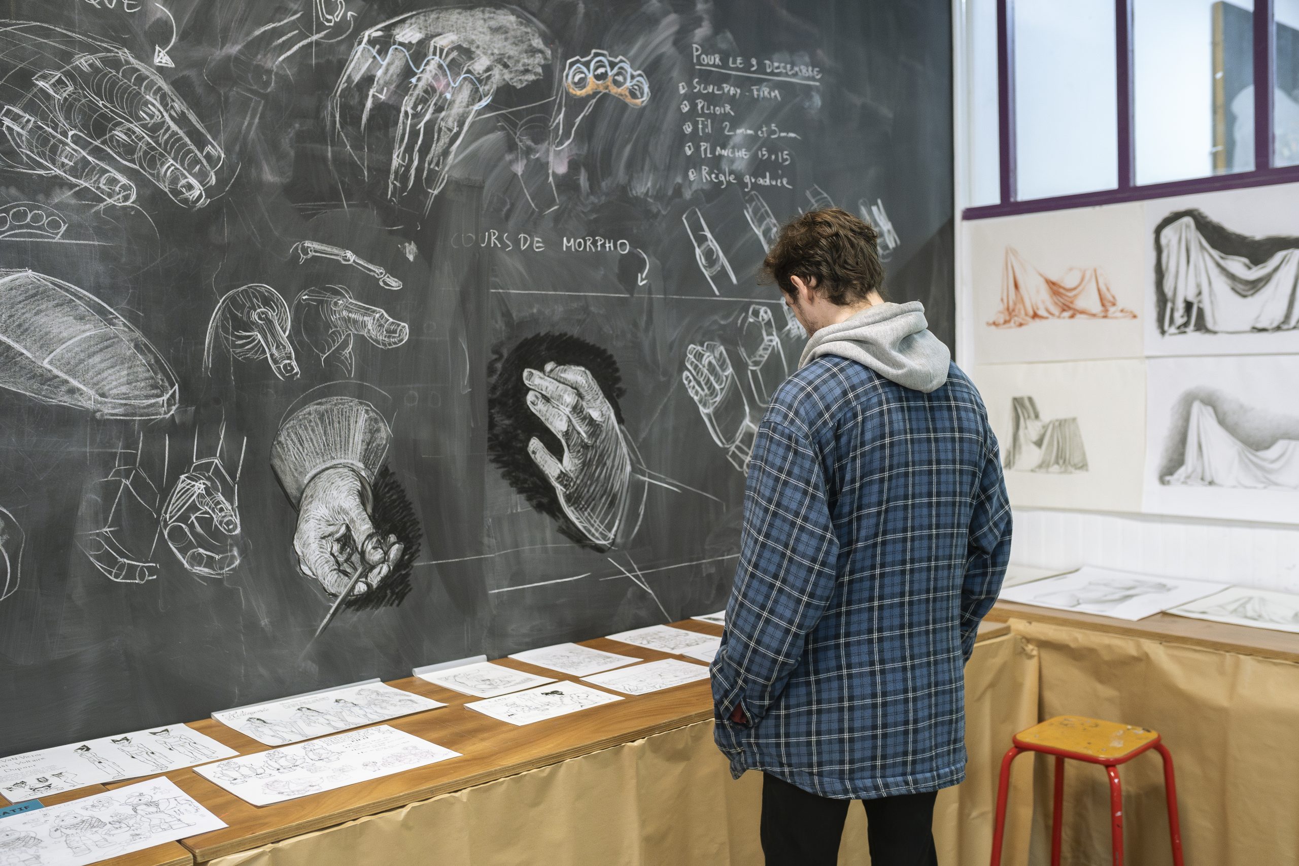 élève devant tableau de dessins à la craie fait à pivaut