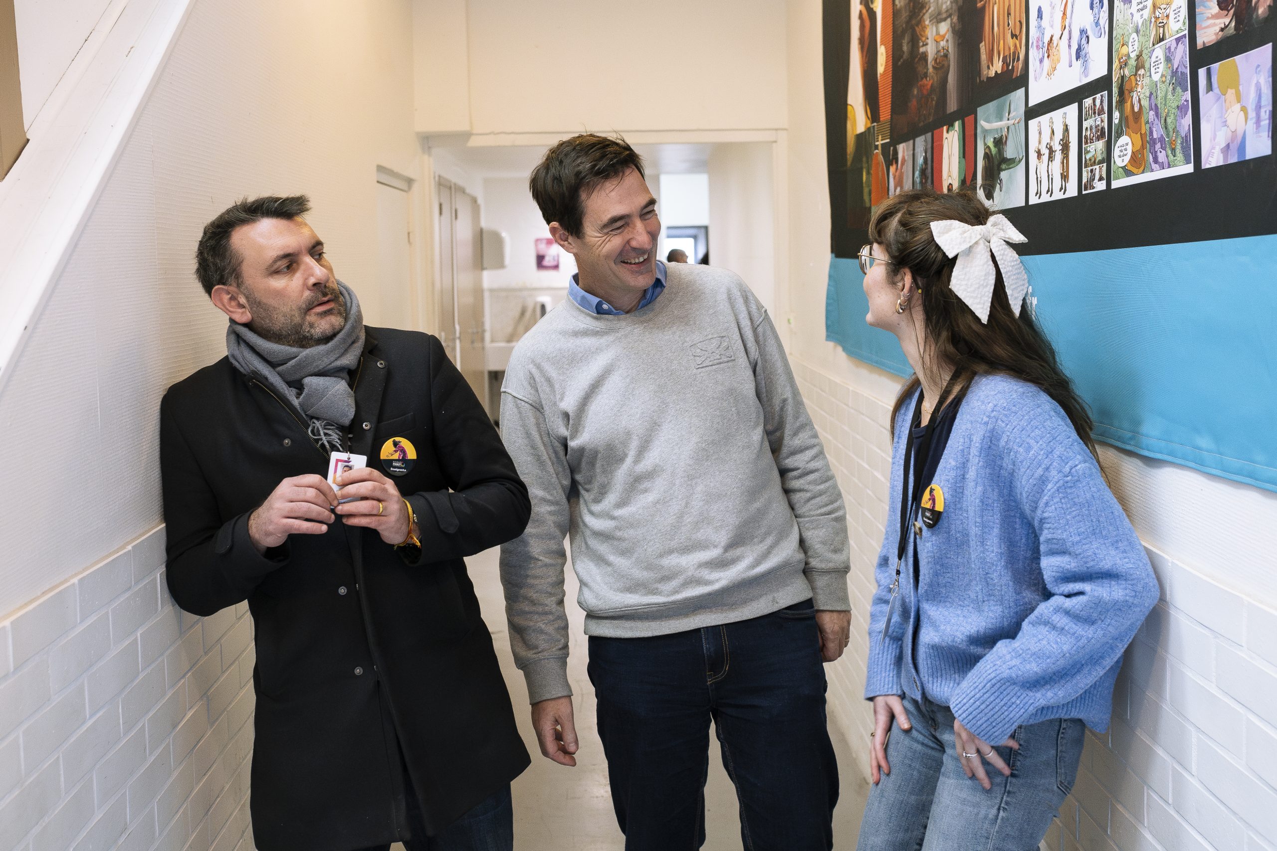 professeurs et élève avec un noeud pivaut discutent dans un couloir de l'école